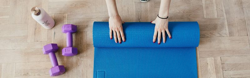 Yoga mat and sneakers on a carbon floor.